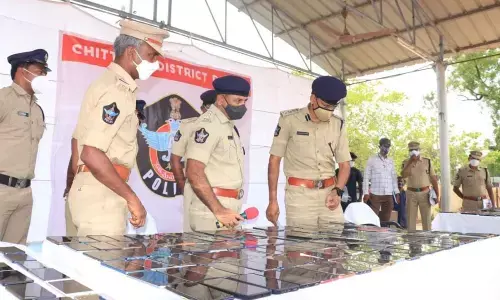 Superintend-ent of Police S Senthil Kumar examines the recovered mobiles in Chittoor on Monday