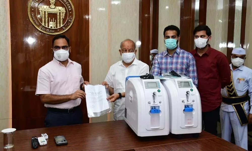 Philanthropists Bhagwandas Karwa, Krishna Karwa and Karthik Karwa handing over 10 oxygen concentrators’ worth over `7 lakhs to Collector K Shashanka at his camp office