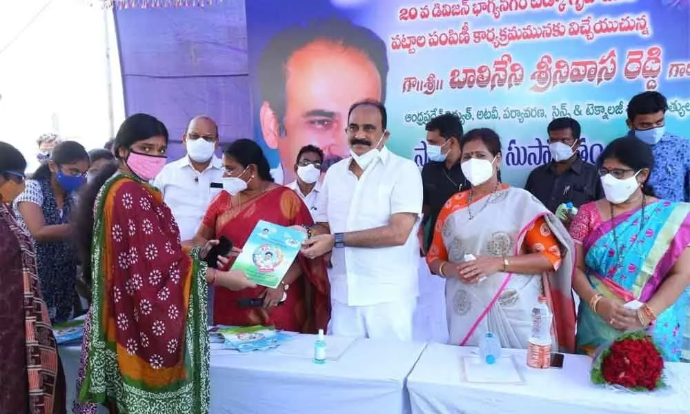 Minister Balineni Srinivasa Reddy presenting documents of a TIDCO house to a beneficiary at a programme in Ongole on Saturday