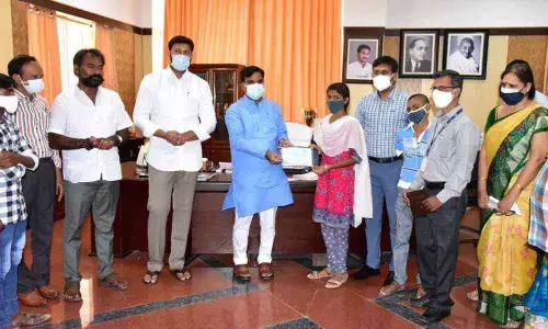 Deputy Chief Minister Amzath Basha handing over bonds to children who lost their parents due to coronavirus in Kadapa on Saturday
