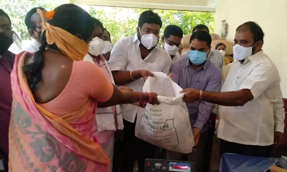 MLA Bhupal Reddy along with DEO Bikshapthi distributing 25 kg rice to a private teacher at a programme at a ration shop at VT Colony in Nalgonda on Sunday