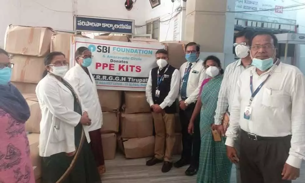 SBI GM S Giridhar and DGM Varadarajan handing over the PPE kits to Ruia hospital superintendent  Dr T Bharathi in Tirupati on Wednesday.
