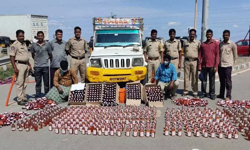 SEB Circle Inspector N Lakshmi Durgaiah and his staff with seized liquor bottles at Panchalingala border check post on Wednesday