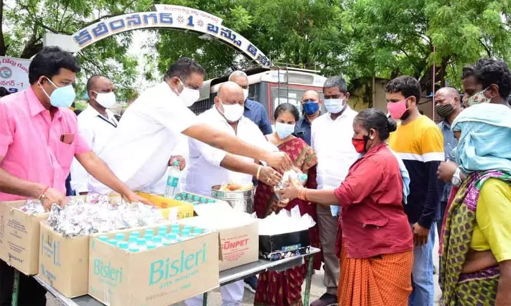 BC Welfare Minister G Kamalakar distributing food packets to the needy at RTC bus stand in Karimnagar on Thursday
