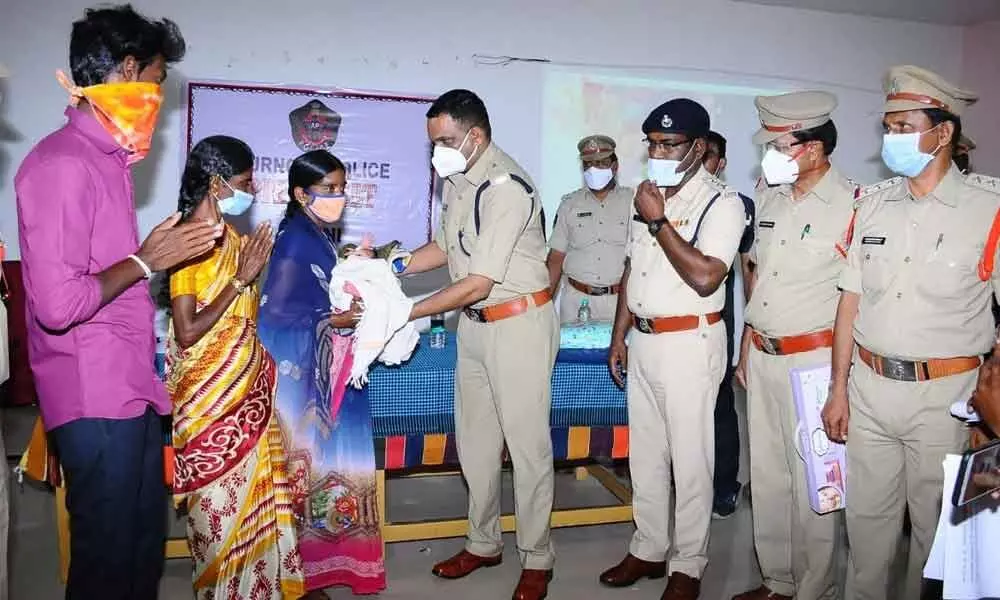 Superintendent of Police Dr Fakkeerappa Kaginelli handing over the kidnapped baby to parents at Arts College in Adoni on Saturday