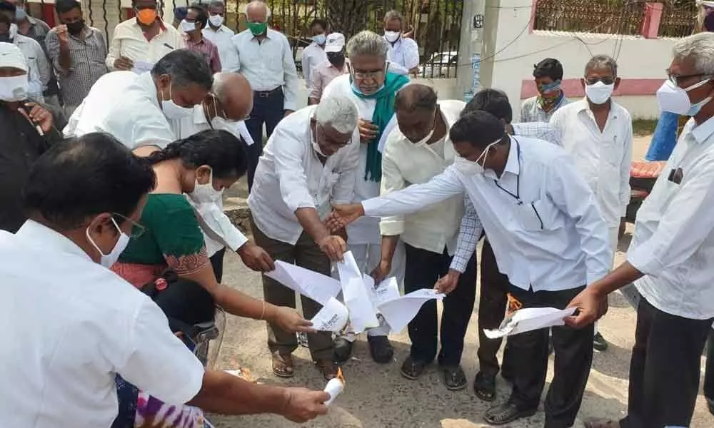 Farmers and leaders of farm workers association burning the copies of three farm laws in Ongole on Saturday