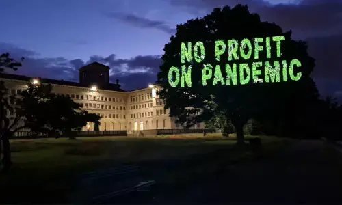 Greenpeace activists flash demand messages ahead of WTO council meet on vaccines