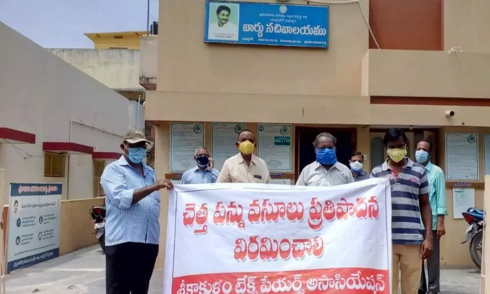 Members  of Srikakulam Taxpayers Association staging a protest in front of  the ward secretariat in 31st division in Srikakulam on Wednesday
