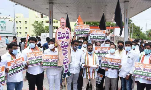 Warangal DCC president Naini Rajender Reddy along with Congress leaders staging a protest at a petrol bunk in Warangal on Friday