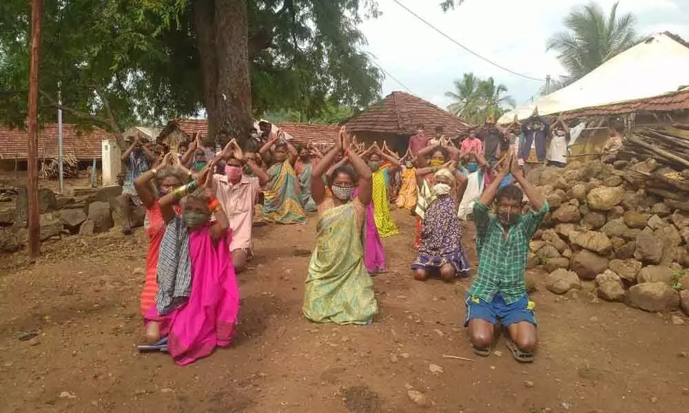 Tribals of Ananthagiri mandal staging a protest kneeling down on the ground, demanding power supply and payment of wages in Visakhapatnam