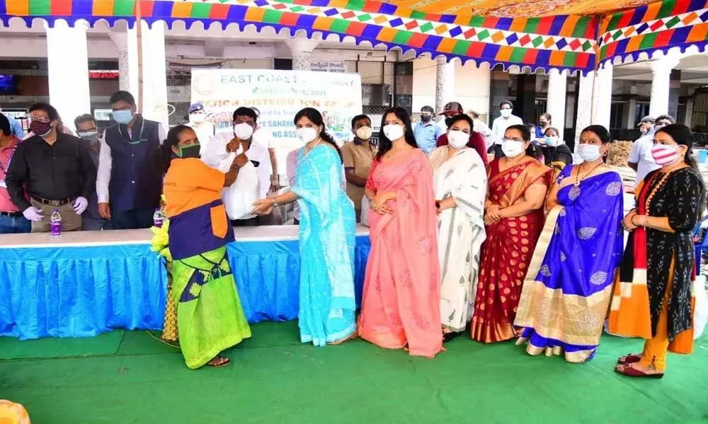 Members of ECoRWWO distributing ration kits to sahayaks and housekeeping staff at Visakhapatnam railway station on Wednesday