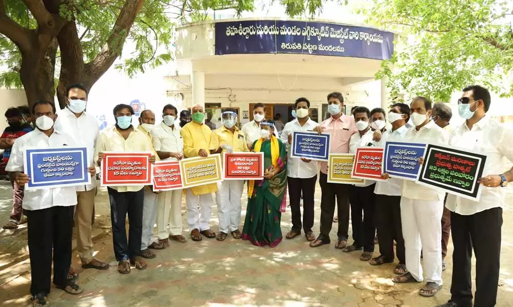 TDP leaders staging a dharna demanding speeding up of vaccination process at Urban MRO office in Tirupati on Wednesday