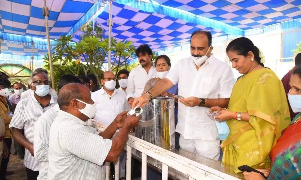 Minister Balineni Srinivasa Reddy and his wife Sachidevi distributing Anandaiah’s preparation to people in Ongole on Wednesday