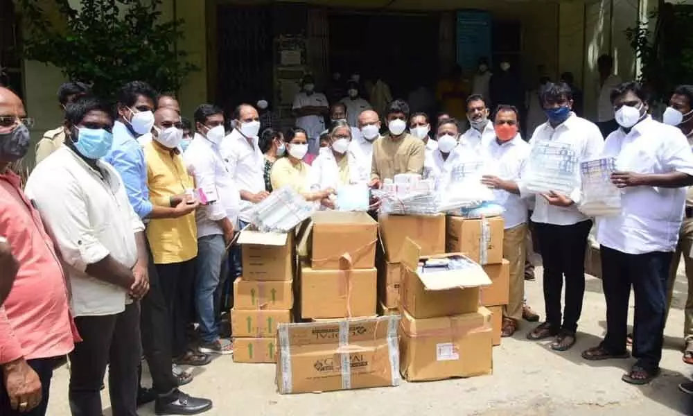 YSRCP leader Raghurami Reddy along with other leaders handing over Rs 2 lakh worth masks and other material to Ruia hospital superintendent Dr Bharathi in Tirupati on Thursday.