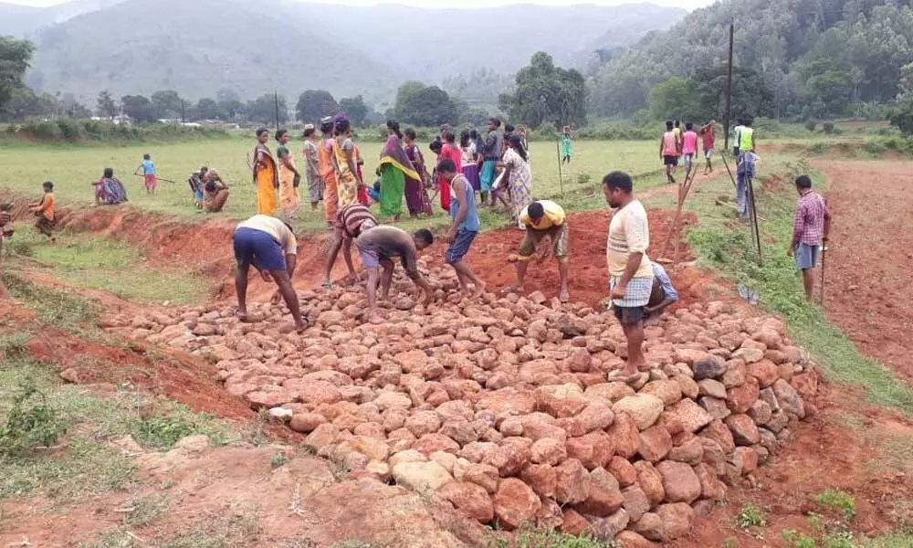Tribals laying a road to Pamulaput village of Kintalangi panchayat in Visakhapatnam