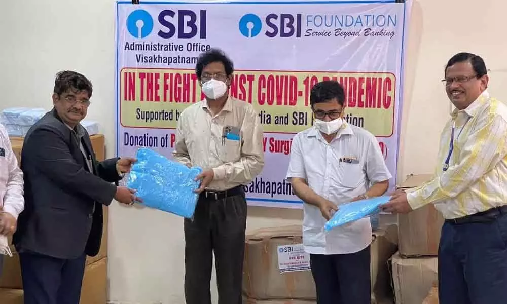 State Bank of India officials donating Covid relief material to AMC Principal P V Sudhakar and District Medical and Health Officer P S Suryanarayana in Visakhapatnam on Thursday