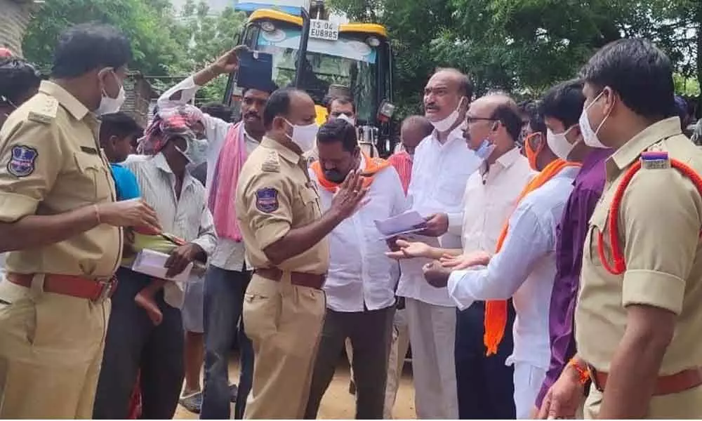 BJP leaders arguing with the police, who are demolishing houses in 20th division of Khammam town on Friday morning