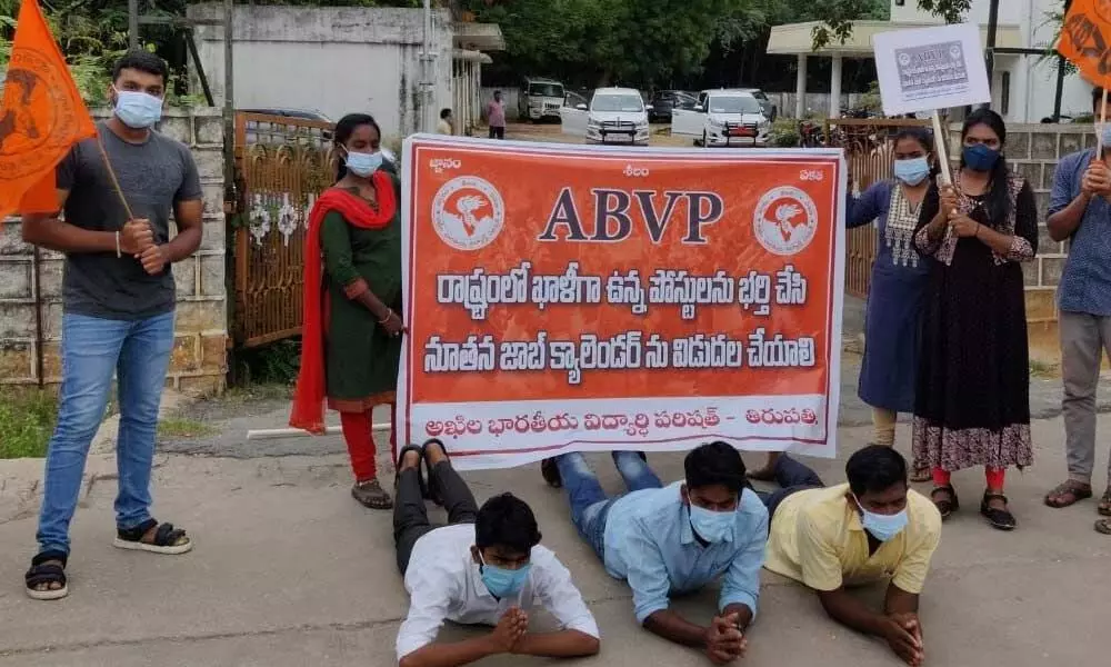ABVP leaders staging a novel protest against job calendar at RDO office in Tirupati on Saturday