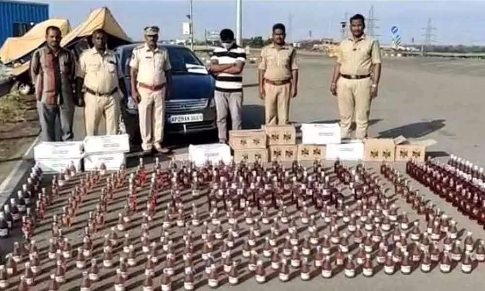 SEB Circle Inspector P Srinivasulu and his staff with seized liquor bottles and accused at Panchalingala border check post on Monday