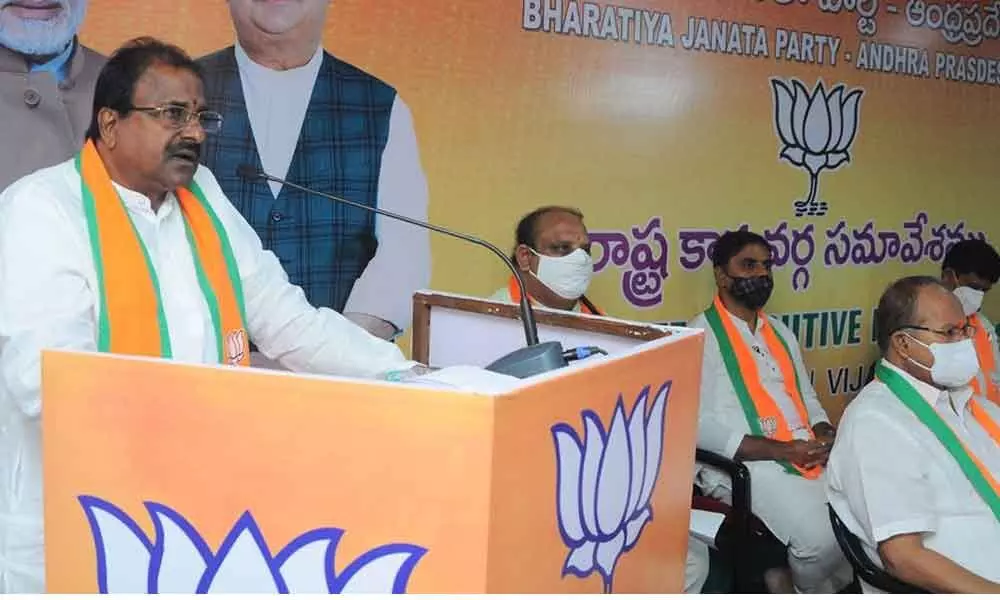 BJP state president Somu Veerraju addresses the party state executive meet in Vijayawada on Monday. Party State former president Kanna Lakshminarayana and others are seen 	(Hans photo: Ch Venkata Mastan)