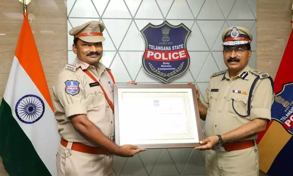 Kodad town CI Narsimha Rao receiving State second award under police station management category from DGP Mahender Reddy at a programme at DGP office on Tuesday