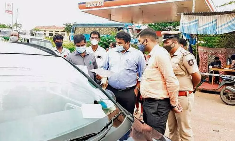 Deputy Commissioner K.V. Rajendra checking passengers from Kerala at the Talapady checkpost on the border with Kerala on Monday.