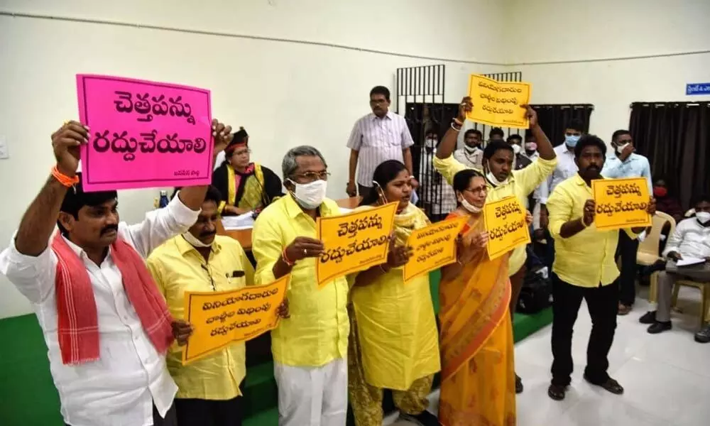 TDP corporators protesting in front of Mayor Gangada Sujathas podium against the user charges and waste tax in the Council meeting in Ongole on Wednesday