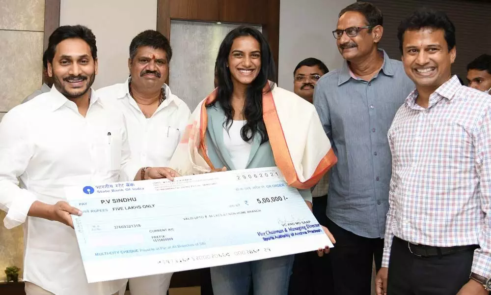 CM YS Jagan Mohan Reddy hands over Rs 5 lakh cheque towards award to badminton player P V Sindhu at the Secretariat on Wednesday