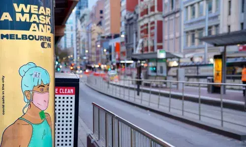 A Wear a Mask sign is seen on a mostly-empty city street during morning commute hours in Melbourne (Pic Source: REUTERS/Sandra Sanders)