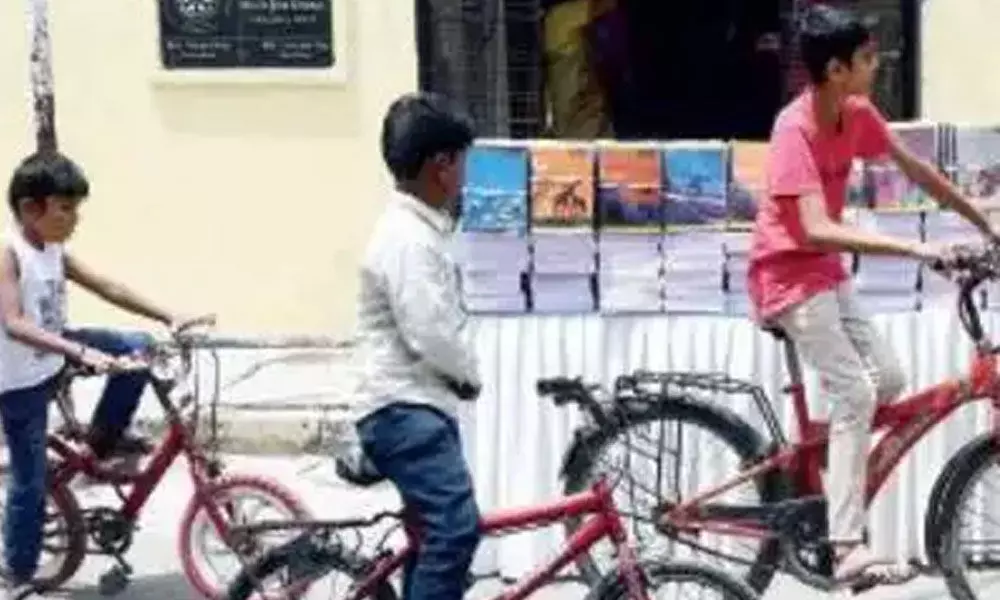 Children inspect books meant to be distributed free in front of a government school in Jayanagar, Bengaluru