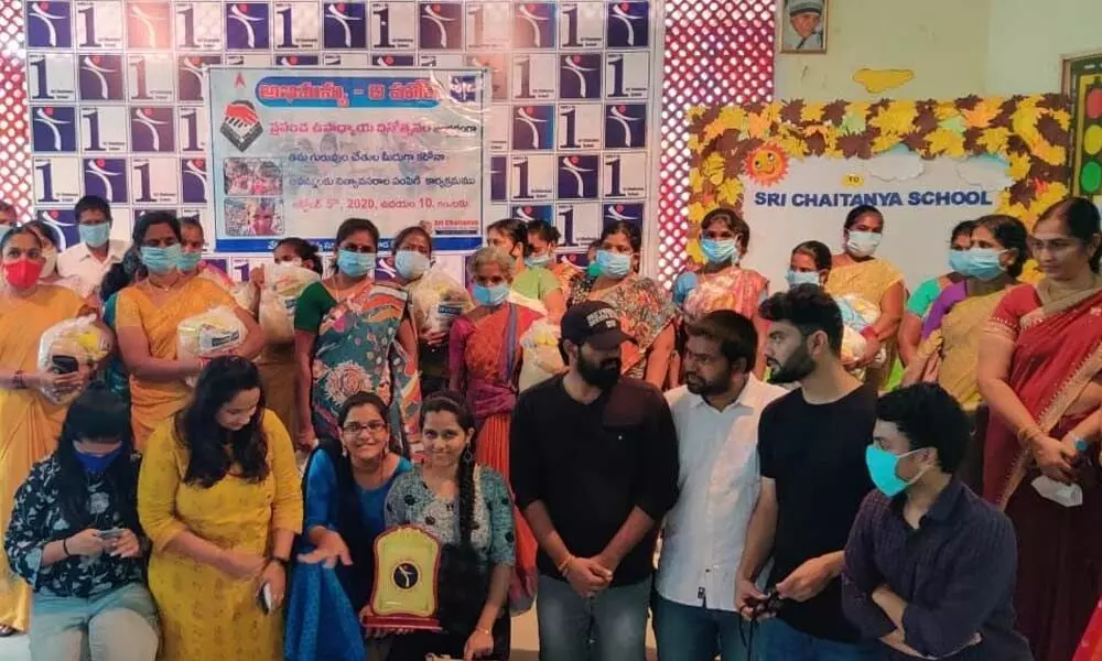 The alumni along with the teachers and non-teaching staff of a private school after distributing groceries to them in Tirupati. (File Photo)