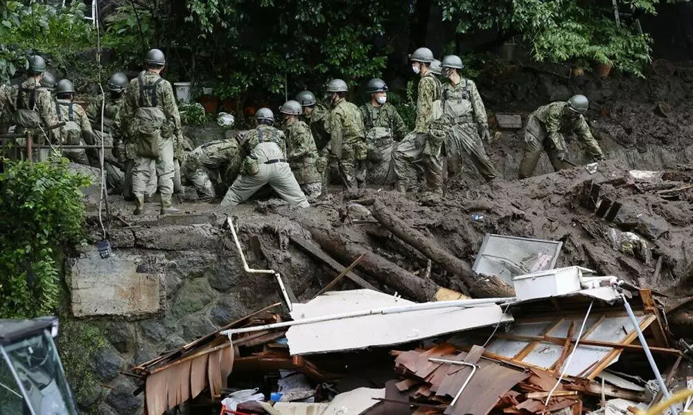 Members of Japanese Self-Defence Forces conduct rescue and search operartion at a mudslide site caused by heavy rain at Izusan district in Atami, west of Tokyo,