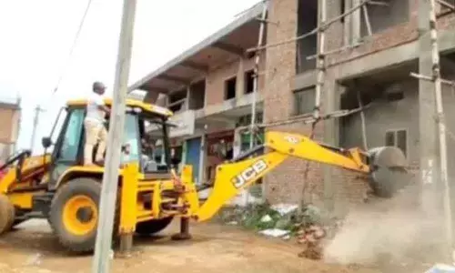 Municipal and Revenue department officials demolishing illegal structures constructed in Wakf Board land at Rythu Nagaram in Nandyal on Monday.