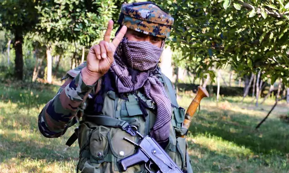 A security personnel shows victory sign during an encounter with militants at Kralgund area of Handwara in Kupwara