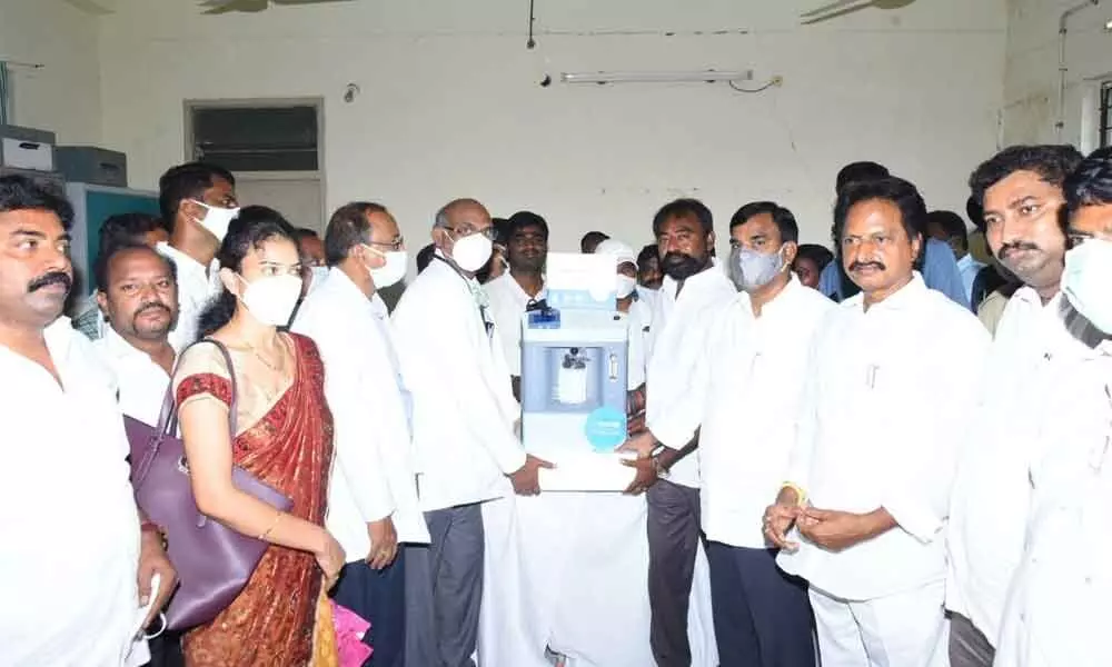 Industrialists Goutham Reddy and Danial donating oxygen concentrators to Deputy Chief Minister Amzath Basha at a programme in Kadapa on Saturday