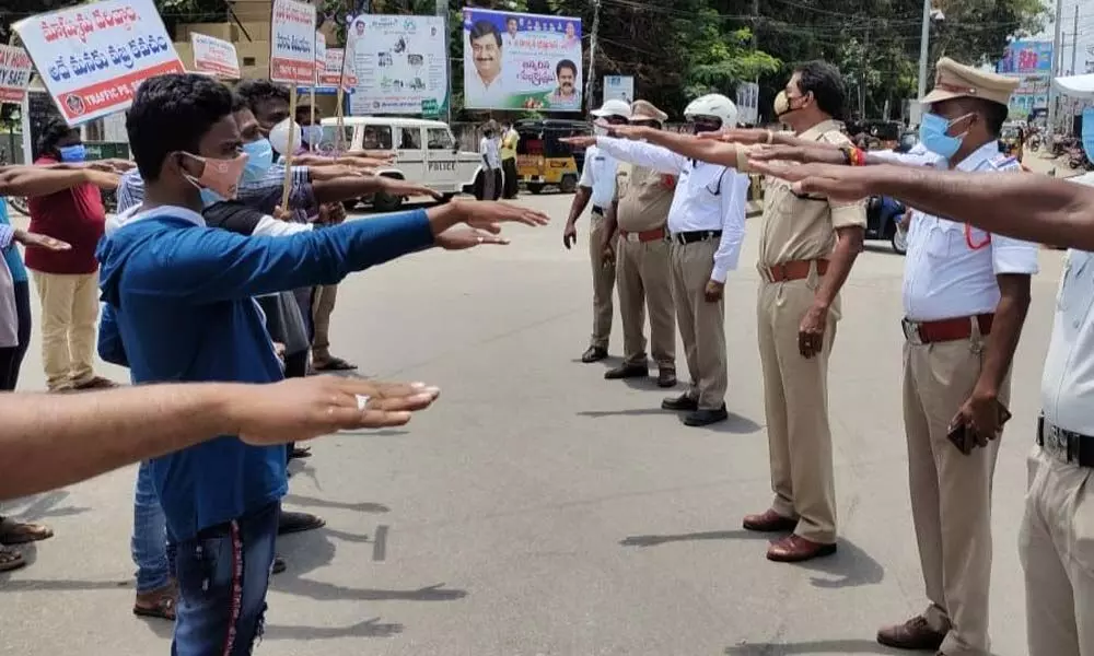 Srikakulam city traffic police administering pledge to youth near APSRTC complex in Srikakulam city on Sunday