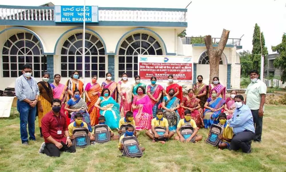 Deepthi Mahila Samithi members and CSR officials seen along with children after the distribution of bags and blankets at Samithi office in Ramagundam on Sunday