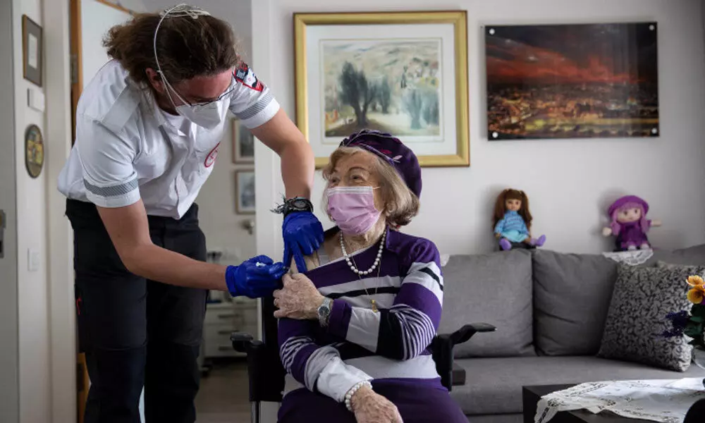 Illustrative: A Magen David Adom worker administers a COVID-19 vaccine to Holocaust survivor Yaffa Balaban, 95, at her apartment in Beit Tovei Hair retirement residence in Jerusalem on January 26, 2021. (Yonatan Sindel/Flash90)