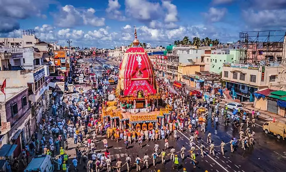 Devotees perform rituals during the annual Rath Yatra festival in Puri on Monday