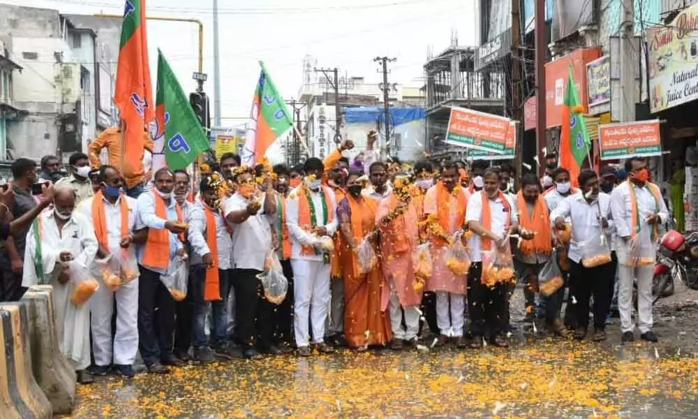 BJP leaders offering flowers to the patholes, as a strange protest in Warangal districe on Monday