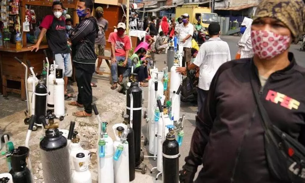 People queue up to refill their oxygen tanks at a filling station in Jakarta, Indonesia. (Photo | AP)