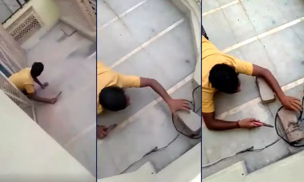 a man crawling like a snake to reach the roof of his house in UPs Muradnagar