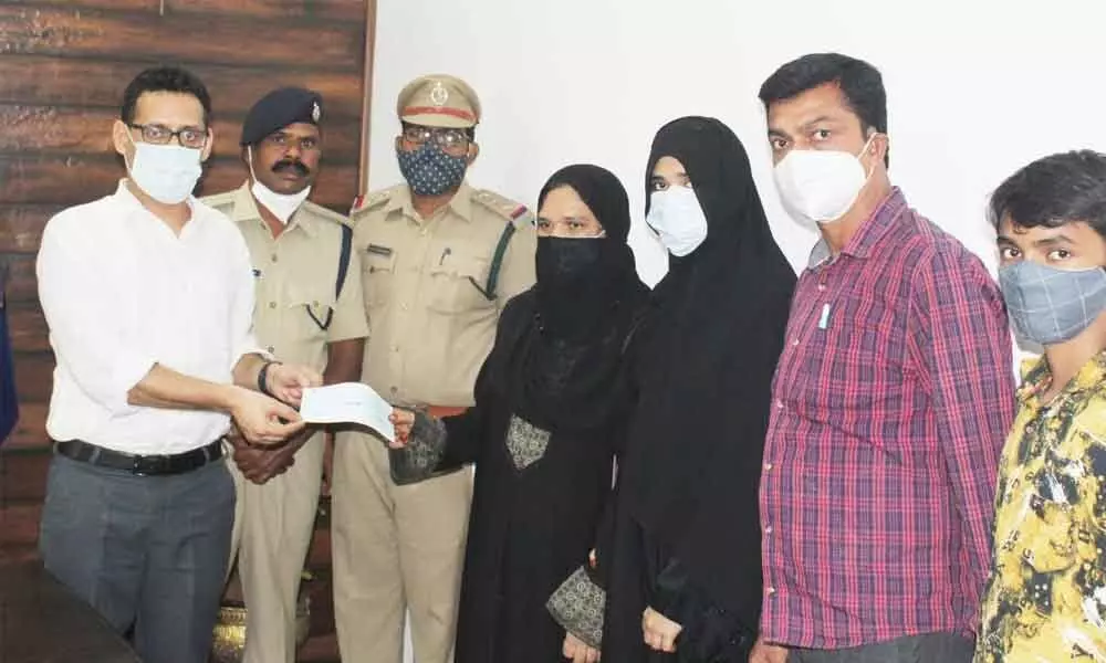 SP Sunil Dutt handing over a cheque to the family members of the deceased head constable at n his office in Kothagudem on Tuesday