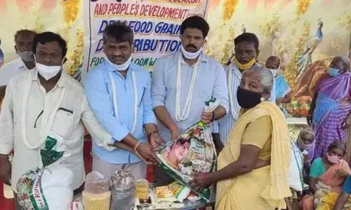 Karanam Venkatesh distributing dry ration to weavers’ families in Chenetha Puri of Vetapalem mandal on Wednesday