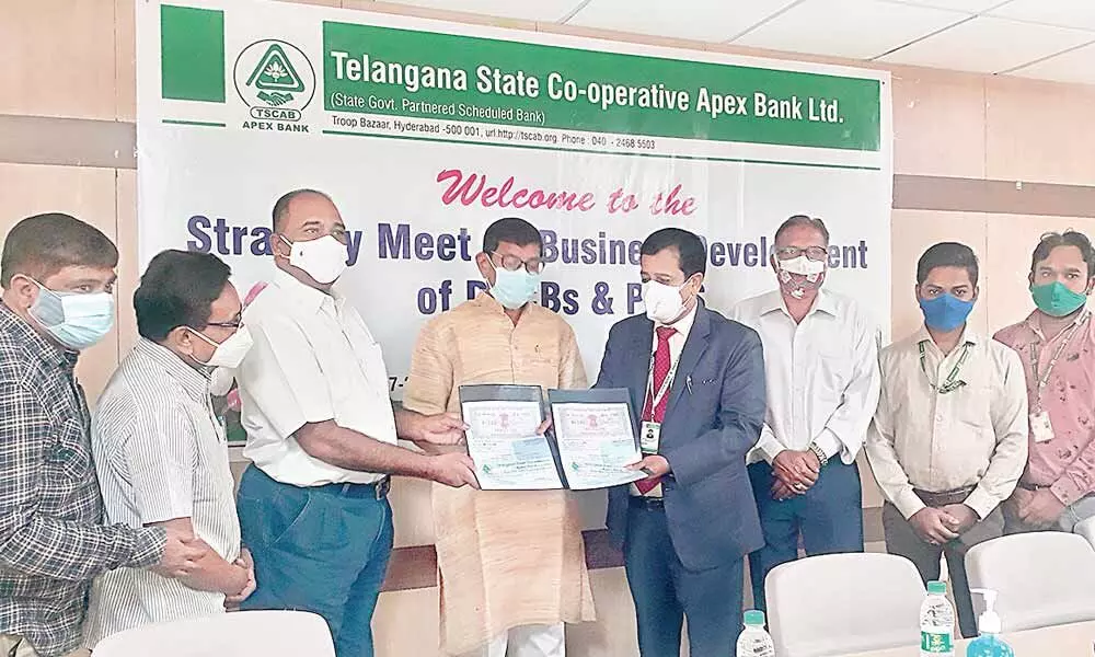 TSCAB Chairman Konduru Ravinder Rao exchanges an MoU with TS Cooperative Rural Irrigation Corporation official in Hyderabad on Thursday