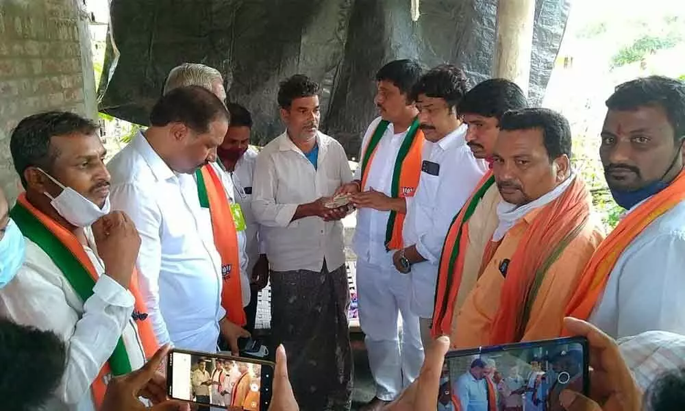BJP district president Galla Satyanarayana handing over financial aid to the bereaved family of jobless youth Borra Narasimha Rao, in Khammam on Saturday