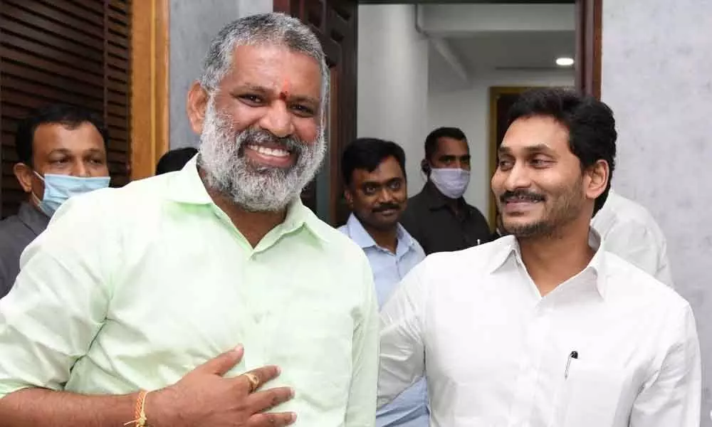 Chief Minister Y S Jagan Mohan Reddy patting MLA Chevireddy Bhaskar Reddy for his efforts in downloading Disha app by people, at camp office in Vijayawada