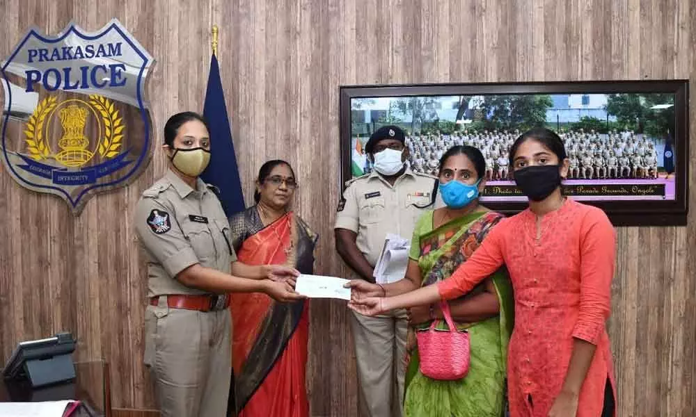 SP Malika Garg presenting a cheque to the family members of a deceased police officer in Ongole on Friday