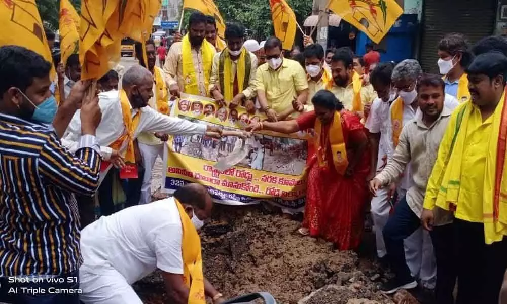 TDP leaders repairing a bad road at Gokul theatre junction in  Visakhapatnam on Saturday
