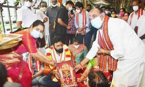 Kanakadurga temple EO Bramaramba and Trust Board chairman P Somi Naidu present portrait of the Durga to Civil Supplies Minister Kodali Nani at the temple on Saturday